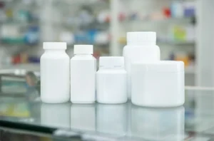 white bottle medicine on counter and shelf medicine in pharmacy background | laiyangpackaging.com